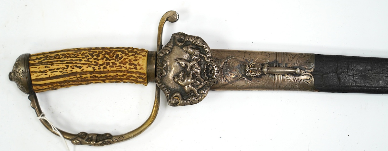 A silver mounted Continental hunting hanger, side guard and knuckle bow with raised decoration, stag horn grip, leather scabbard with later engraved silver mounts, blade 48.5cm. Condition - good